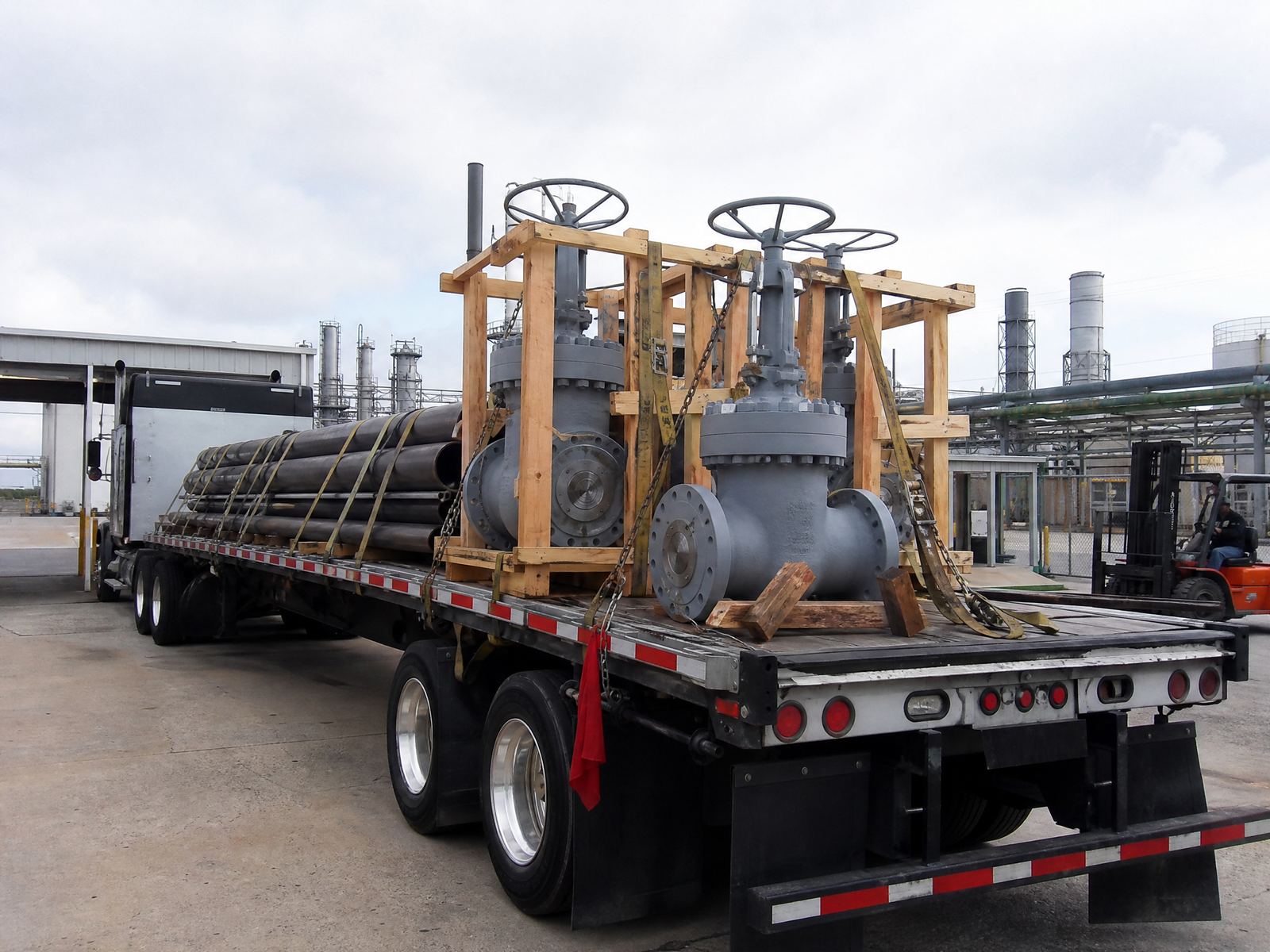 Flatbed truck loaded with crated surplus valves — we arrange and pay all freight
